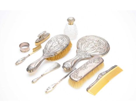 An Art Nouveau silver mounted hand mirror, Birmingham 1910, together with an associated silver mounted brush and comb, a silv