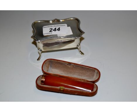 An Edwardian silver shaped rectangular trinket box, Birmingham 1908; a 9ct gold amber cigar holder , cased 