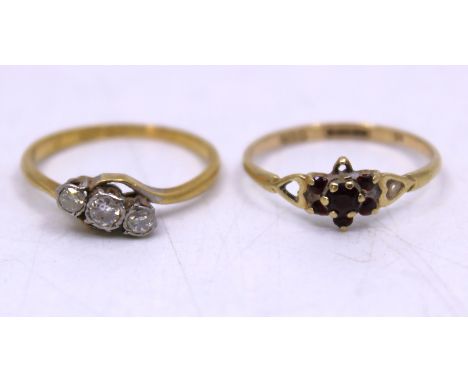 Two Gold Rings. To include an 18ct Gold and Platinum Three Stone Diamond Ring and a 9ct Gold Garnet Cluster Ring.  The 18ct Y