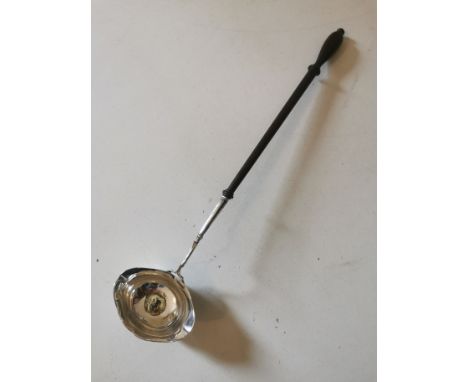 A Georgian white metal, double spouted punch ladle with coin pressed into the bottom of the bowl and a turned wooden handle. 