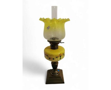 A Victorian oil lamp with brass base and column, yellow opaline glass oil well painted with flowers and a yellow frilled neck
