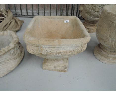 A square concrete planter on plinth