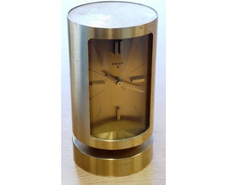 ADDED LOT    An unusual and stylish circular gilt metal eight day Swiss alarm clock, convex glass before a gilded face signed