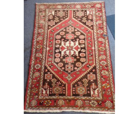 A hand knotted Turkish woollen carpet, central stylised star design against a cream ground and surrounded by stylised flower 