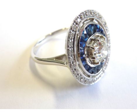 An Art Deco style 18-carat white gold ring set with a 1 carat diamond surrounded by sapphires and diamonds 