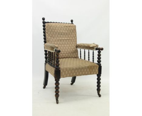 19th century ebonised bobbin-turned armchair in the manner of William Morris, raised on castors CONDITION REPORT Wear to the 