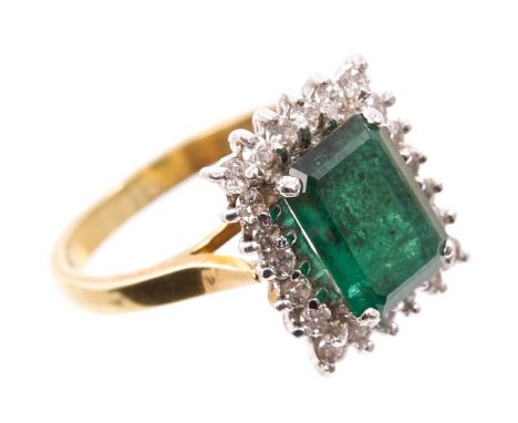 Emerald and diamond cluster ring with a large rectangular step cut emerald measuring 9.70mm x 6.80mm x 3.70mm, surrounded by 