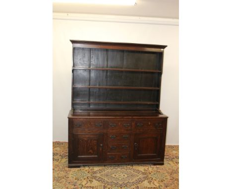 19th century oak high dresser with boarded rack, the base enclosed by three frieze drawers and two cupboards below flanking f