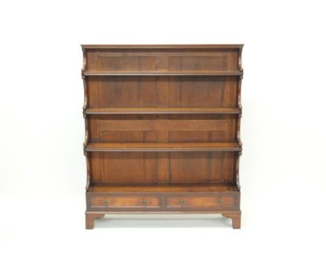 Early 19th century mahogany waterfall-front open bookcase with four graduated shelves and two drawers below, on bracket feet,