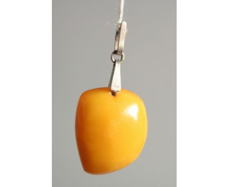 A SMALL RUSSIAN BUTTER SCOTCH AMBER PENDANT with a Russian silver ring. 4.2gms.
