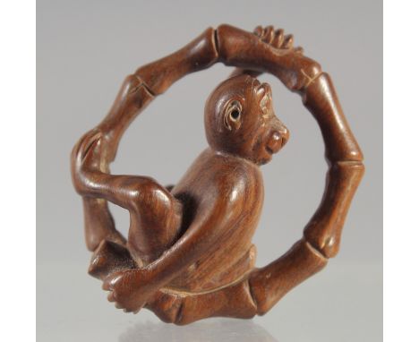 A CARVED WOOD NETSUKE, MONKEY 1.5ins, signed.
