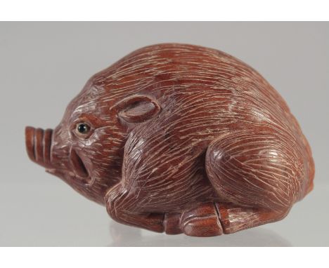 A CARVED WOOD NETSUKE, HOG.2.5ins Signed.