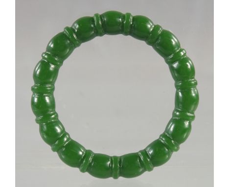 A RIBBED GREEN JADE BANGLE. 2.75ins diameter.