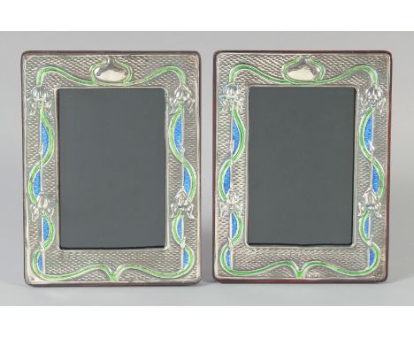A PAIR OF ART NOUVEAU SILVER AND ENAMEL PHOTOGRAPH FRAMES. 7.5ins x 5.75ins