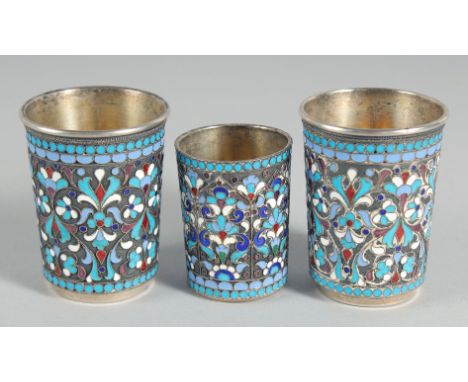 A PAIR OF RUSSIAN SILVER AND ENAMEL BEAKERS, 2.25ins and a smaller beaker, 1.75ins high. (3).