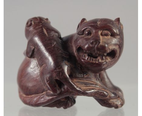 A CARVED WOOD NETSUKE, DOG OF FOU. 1.5ins, signed.