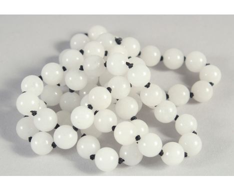 A STRING OF SIXTY WHITE JADE BEADS. 28ins long.