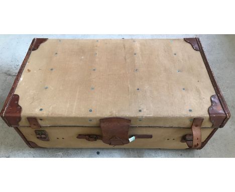 A vintage travelling trunk with leather banding and straps. Complete with key. Monogrammed D.G.L. Approx 92cm x 54cm x 33cm.