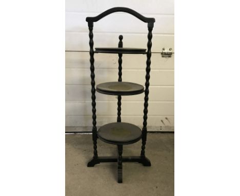 A  oak 3 tier cake stand with green baize inserts and bobbin style legs.  Approx 85cm tall.