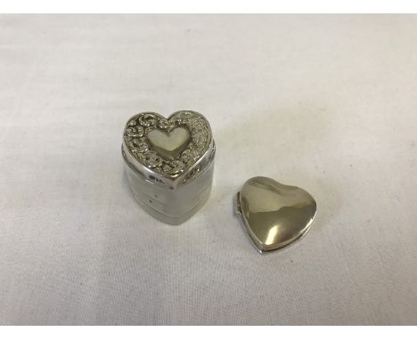 A small hallmarked silver hinge lidded heart shaped pill box. Together with a silver topped heart shaped glass trinket pot. 