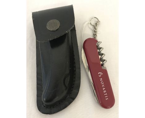 A Swiss Army Novartis multi-tool penknife in leather sheath.  