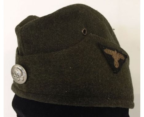 A WWII style SS-VT M34 overseas cap. Skull and crossbones button to front, eagle cloth badge to side. 