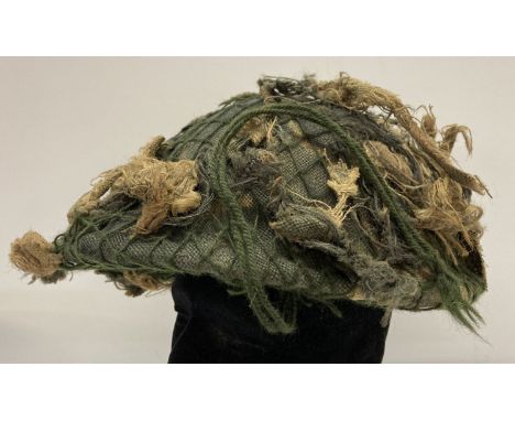 A British turtle helmet with camo cover and liner. Liner has ministry marked label dating 1976. 