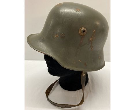 A WWI style Austrian M17 helmet with liner and chin strap.  