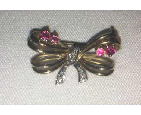 9ct gold bow brooch set with four rubies and seven small diamonds.