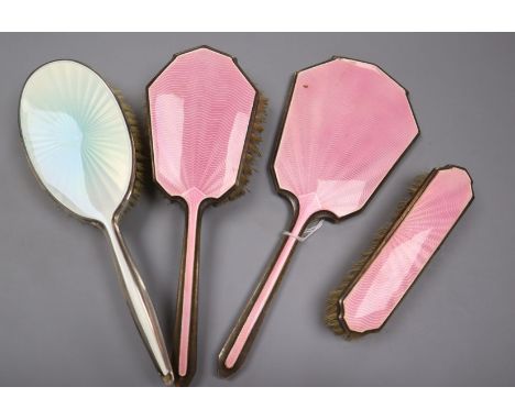 A George VI silver and pink guilloche enamel three piece mirror and brush set, Birmingham, 1947 and one other silver &amp; en