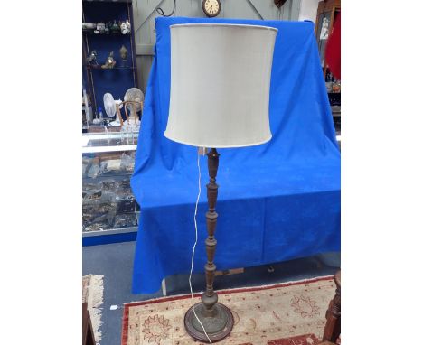 A CAST METAL STANDARD LAMP OF ASIAN DESIGN on wooden plinth, 131cm high with shade for same