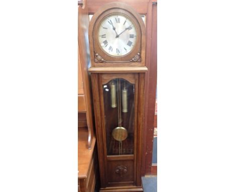 A 1920S OAK LONGCASE CLOCK with arched top, striking on rods