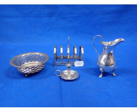 A SILVER CREAM JUG Sheffield 1923, with a silver toastrack, a silver bonbon dish and a miniature chamber candlestick