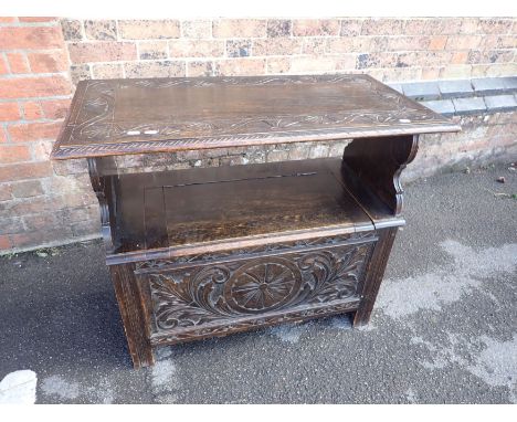 AN OAK MONK'S BENCH WITH CARVED FRONT PANEL 91cm wide