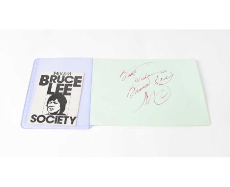 BRUCE LEE; a torn page from an autograph album bearing the signature of Bruce Lee and a 'The K.F.M Bruce Lee Society' members