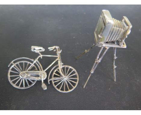 A hallmarked silver miniature camera on tripod stand and a miniature bicycle approx 2 troy oz - some mild bending to bicycle 