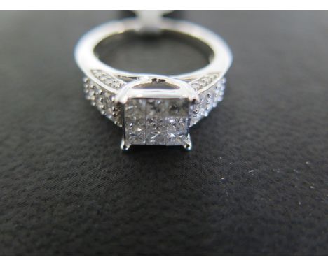 A 9ct white gold illusion cut diamond ring, nine square cut diamonds to shoulder flanked by twelve small round cut diamonds -