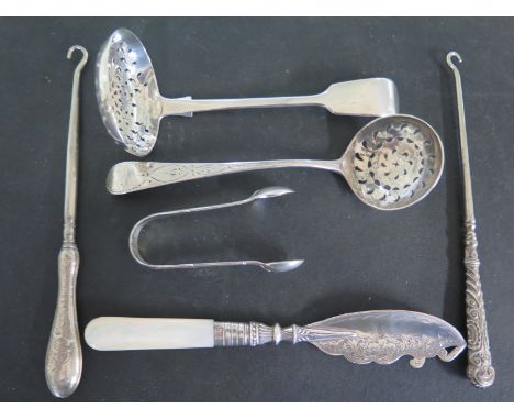 Two hallmarked silver strainer ladles, a pair of sugar nips, two silver handled button hooks and a mother of pearl handled si