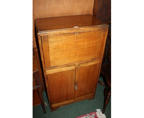 Basil Sharland oak bureau cabinet, produced in the 1930s, the fall opening to reveal shelves of various sizes, above two door