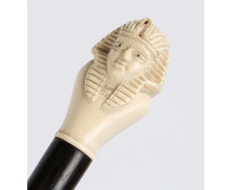 Early 20th Century ivory swagger stick, with an Egyptian carved ivory head to the top, 61cm high