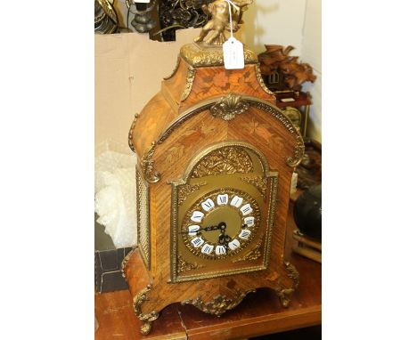 19th Century French style mantel clock, the marquetry inlaid case with brass putto pediment, the dial with Roman numerals, wi