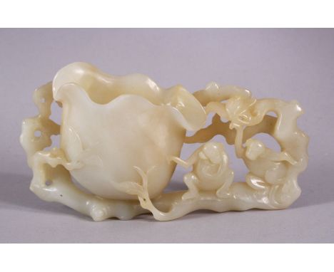 A CHINESE CARVED WHITE JADE LOTUS &amp; MONEY BRUSH WASH, depicting two moneys seated upon the foliage from the lotus formed 