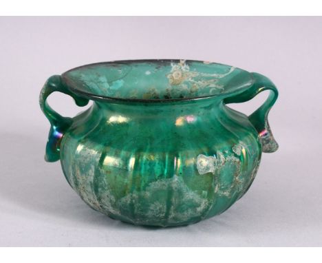 A RARE EARLY ISLAMIC OR ROMAN BLUE GLASS TWIN HANDLED BOWL,  with twin moulded handles and a flared rim, 12cm diameter.