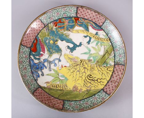 A CHINESE ENAMEL PORCELAIN DRAGON CHARGER, decorated with a dragon and a tiger, with floral borders, 39cm