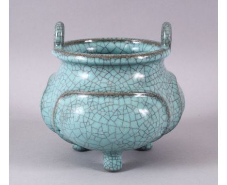 A CHINESE PALE BLUE GUAN GLAZED PORCELAIN TRIPOD CENSER, with moulded panel section, tripot feet and twin handles, 13cm.