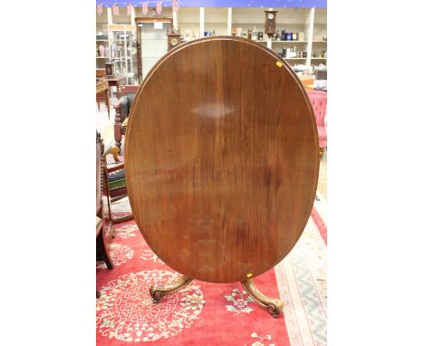 A Victorian mahogany tilt top raised on a tripod base with three scroll carved cabriole legs 