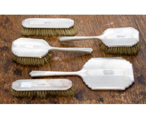 An Art Deco silver dressing table brush set, comprising two hairbrushes, two clothes brushes and a silver hand mirror, Birmin