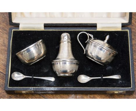 A George V silver three piece cruet with engine turning, salt, pepperette and mustard (hinge af) and pair of spoons, Birmingh