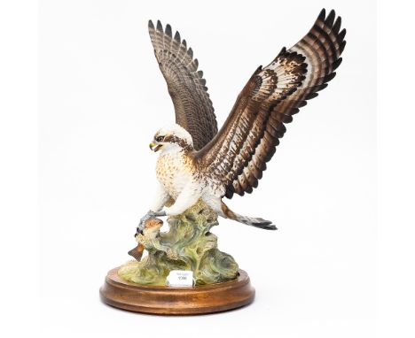 An ceramic figure of a "Sea Eagle" catching a fish, on plinth,