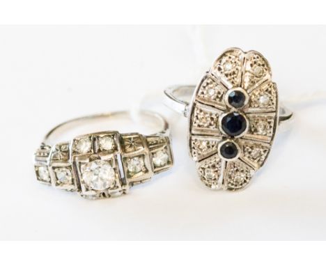 Two Art Deco style white metal rings, one set with three centre vertical sapphires and diamond chip surround, millegrain edge